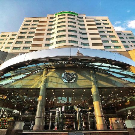 Evergreen Laurel Hotel - Taichung Luaran gambar The photo shows the exterior of a modern hotel building. The entrance features a large, glass canopy supported by columns, creating a welcoming area. The facade of the hotel is composed of a mix of glass and concrete, with large windows that suggest 