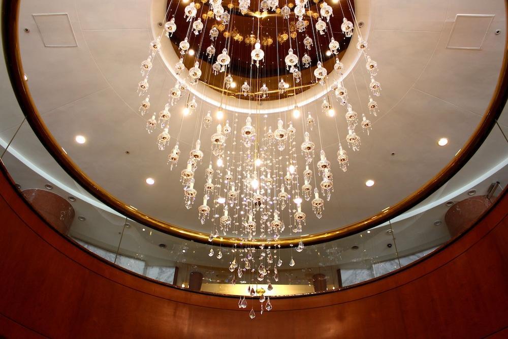 Evergreen Laurel Hotel - Taichung Luaran gambar The photo shows an elegant chandelier hanging from a ceiling. The chandelier features numerous hanging crystals that reflect light, creating a sparkling effect. The ceiling itself is circular and designed with a smooth surface, accented by a circular