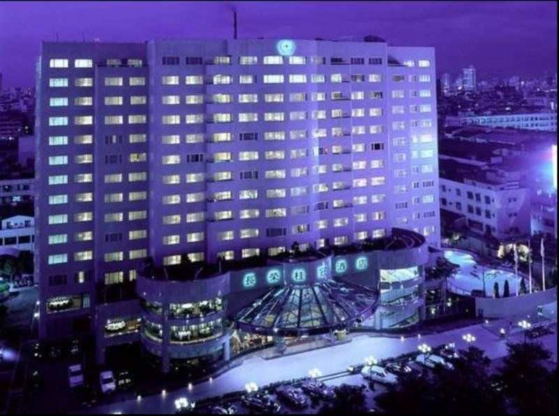 Evergreen Laurel Hotel - Taichung Luaran gambar The photo shows a large hotel building illuminated in a purple hue during the evening or nighttime. The facade features numerous windows, many of which are lit, suggesting occupancy. The entrance area appears modern and curved, with a design that inc