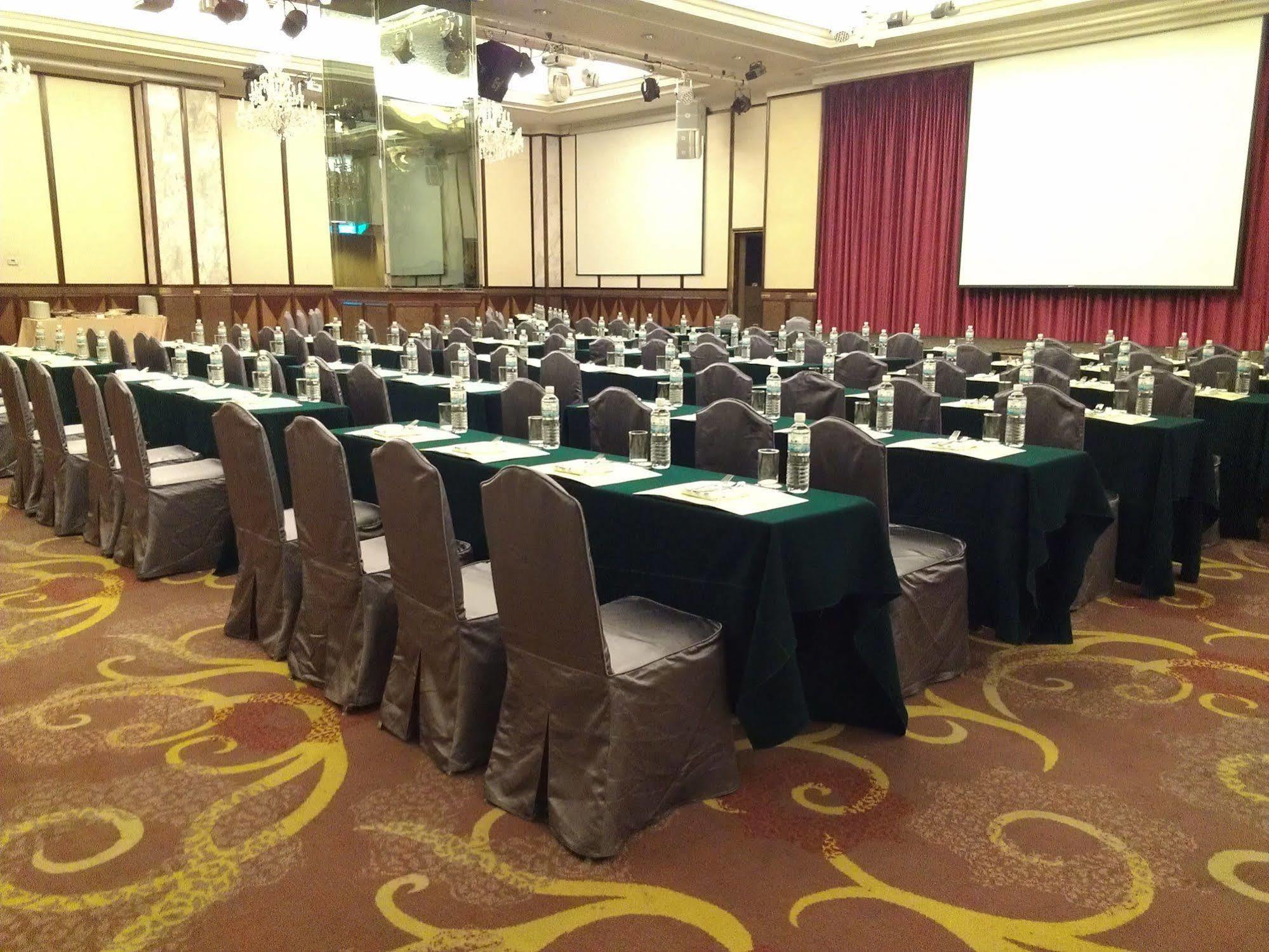 Evergreen Laurel Hotel - Taichung Luaran gambar The photo shows a large conference or meeting room set up with multiple tables arranged in a structured manner. Each table is covered with a tablecloth, alternating between black and green. There are chairs around each table, and each place setting a