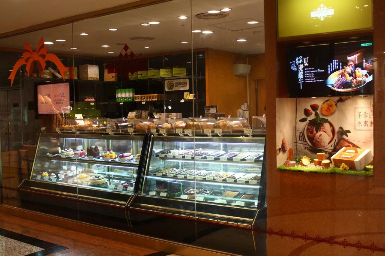 Evergreen Laurel Hotel - Taichung Luaran gambar The photo shows a display case in a bakery or dessert shop. The glass case is filled with a variety of pastries, cakes, and desserts arranged neatly. Behind the display, there is a counter with additional items and desserts visible. The walls are dec