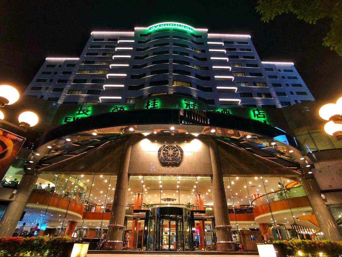 Evergreen Laurel Hotel - Taichung Luaran gambar The photo shows a modern building at night, featuring a grand entrance with illuminated signage. The structure has multiple stories with a sleek design, adorned with green lighting that highlights its architectural features. The entrance is spacious 