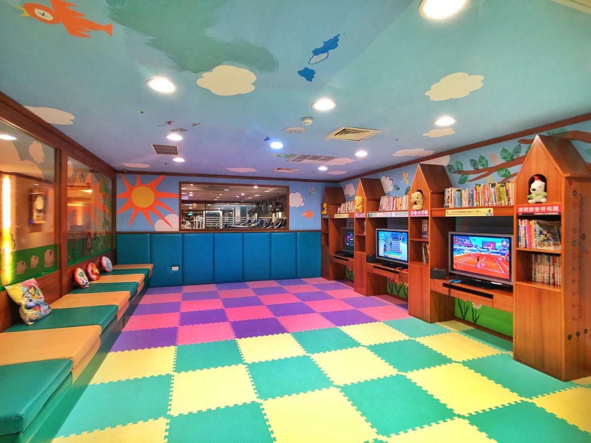 Evergreen Laurel Hotel - Taichung Luaran gambar The photo shows a brightly colored children's playroom or activity area. The floor is covered with large colorful tiles in shades of blue, green, yellow, and pink, creating a playful pattern. The walls have cheerful decorations, including sun and clo