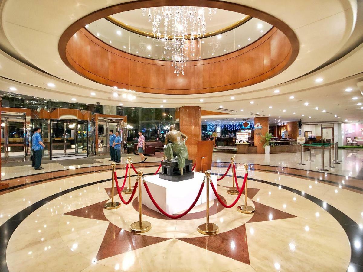 Evergreen Laurel Hotel - Taichung Luaran gambar The image shows a spacious lobby area of a building, likely a hotel or an upscale establishment. The design features a circular ceiling with a chandelier hanging from it, creating a bright and elegant ambiance. At the center, there is a statue, likel
