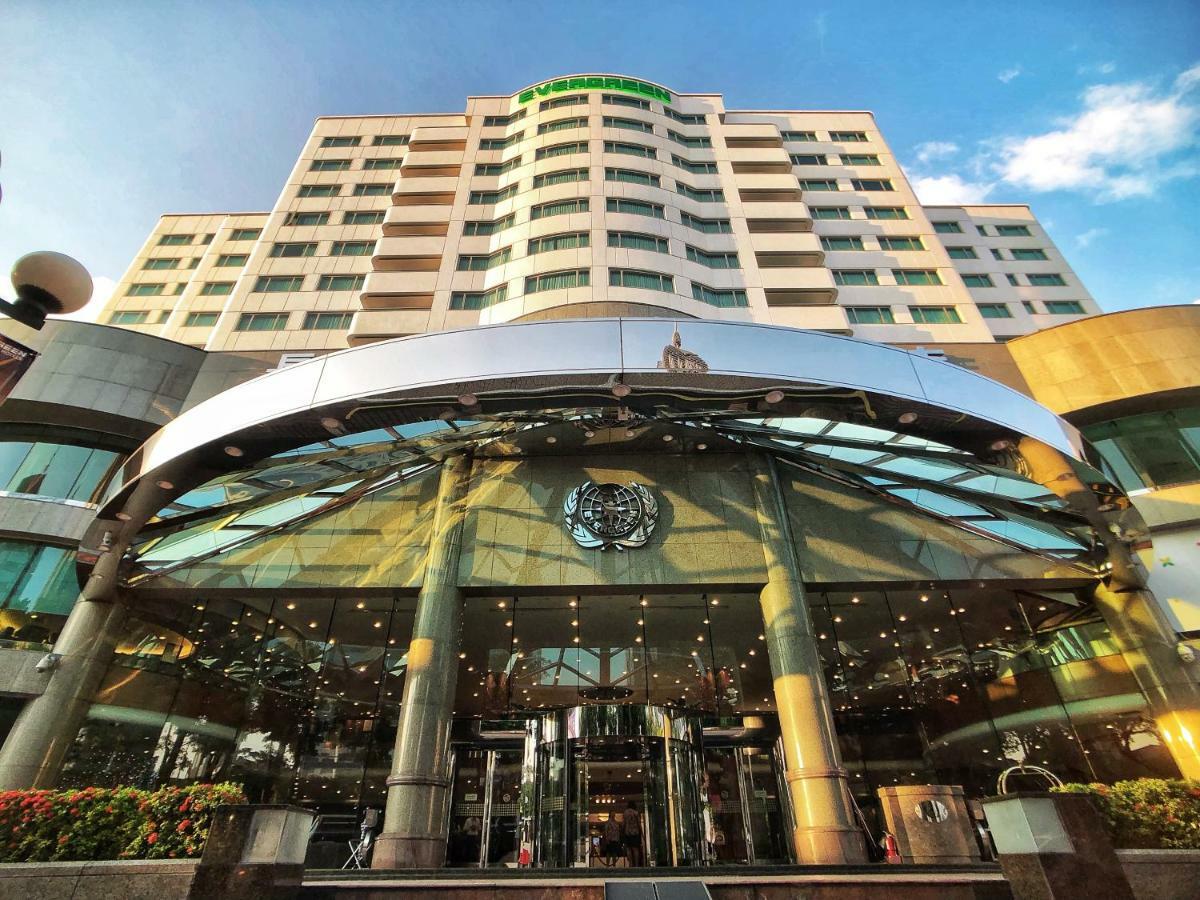 Evergreen Laurel Hotel - Taichung Luaran gambar The photo shows the exterior of a modern hotel building. The entrance features a large, glass canopy supported by columns, creating a welcoming area. The facade of the hotel is composed of a mix of glass and concrete, with large windows that suggest 