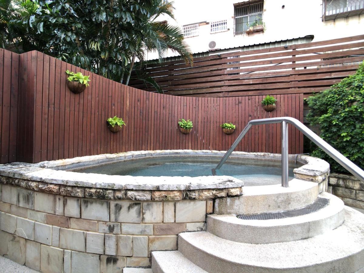 Evergreen Laurel Hotel - Taichung Luaran gambar The photo shows a small outdoor hot tub or spa area. It's surrounded by a wooden fence, with several planters containing greenery attached to the wall. The hot tub is round, with a stone border, and there are steps leading up to it with a stainless s