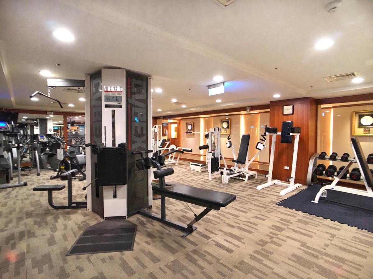 Evergreen Laurel Hotel - Taichung Luaran gambar The photo shows an indoor gym or fitness area. It features various workout equipment, including:

- A multi-station gym machine in the center for strength training.
- Weight benches and free weights organized on shelves.
- Cardio equipment, likely tr