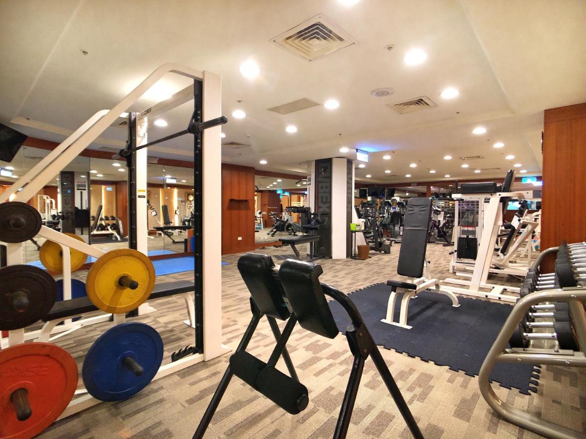Evergreen Laurel Hotel - Taichung Luaran gambar The photo shows a gym interior with various workout equipment. On the left, there are weights of different colors stacked on a weight rack. In the foreground, there's a bench for exercises, and in the background, multiple machines for strength traini